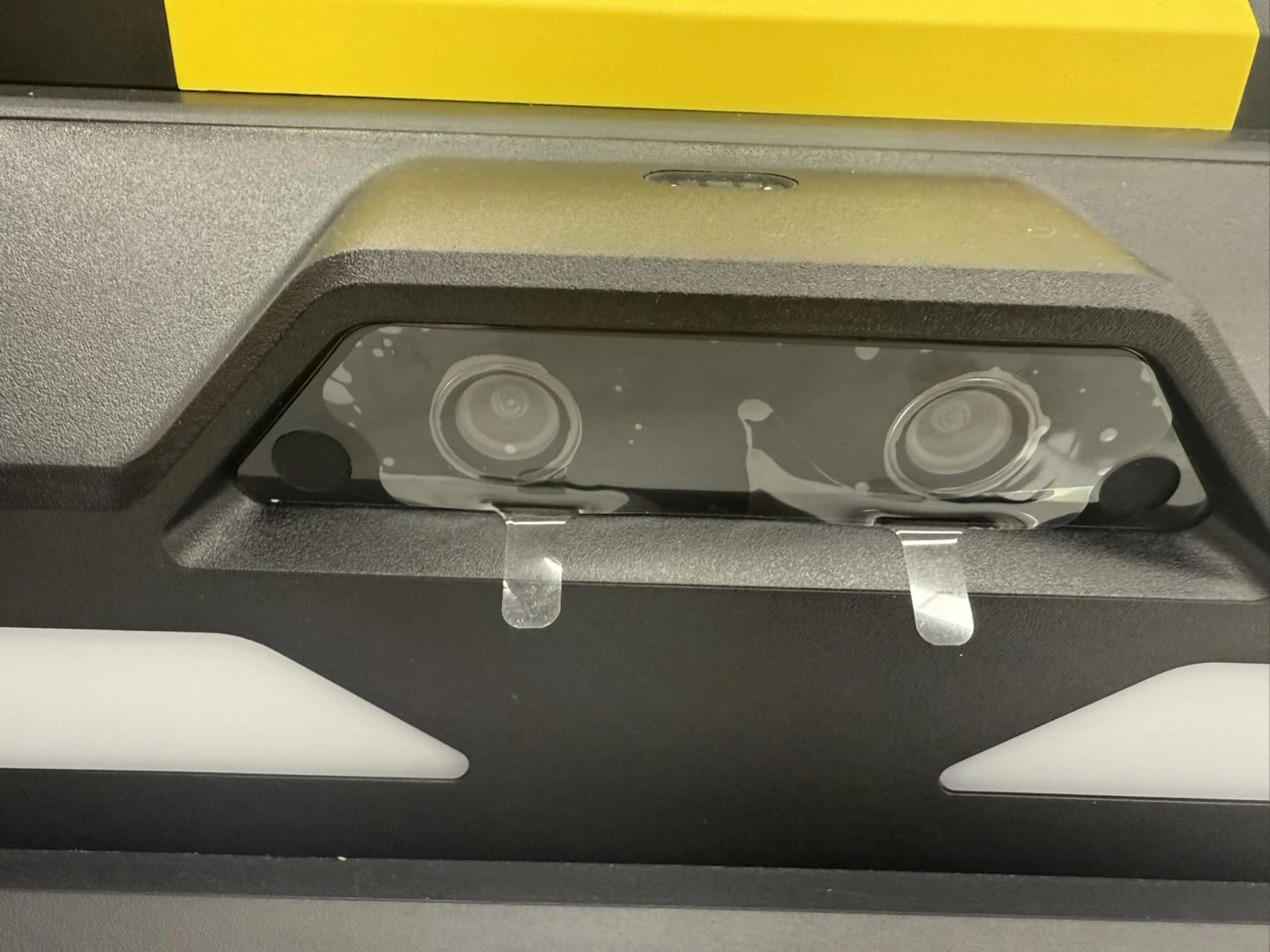 2つのカメラレンズ前面に透明な保護フィルムとつまみが残っている実機写真